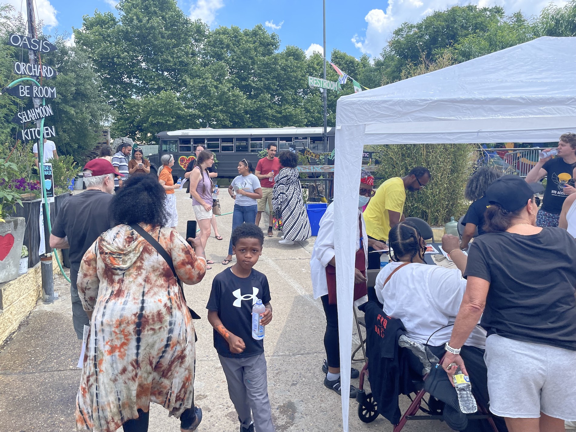 A picture shows people lined up for food and a young kid in the foreground of the photo