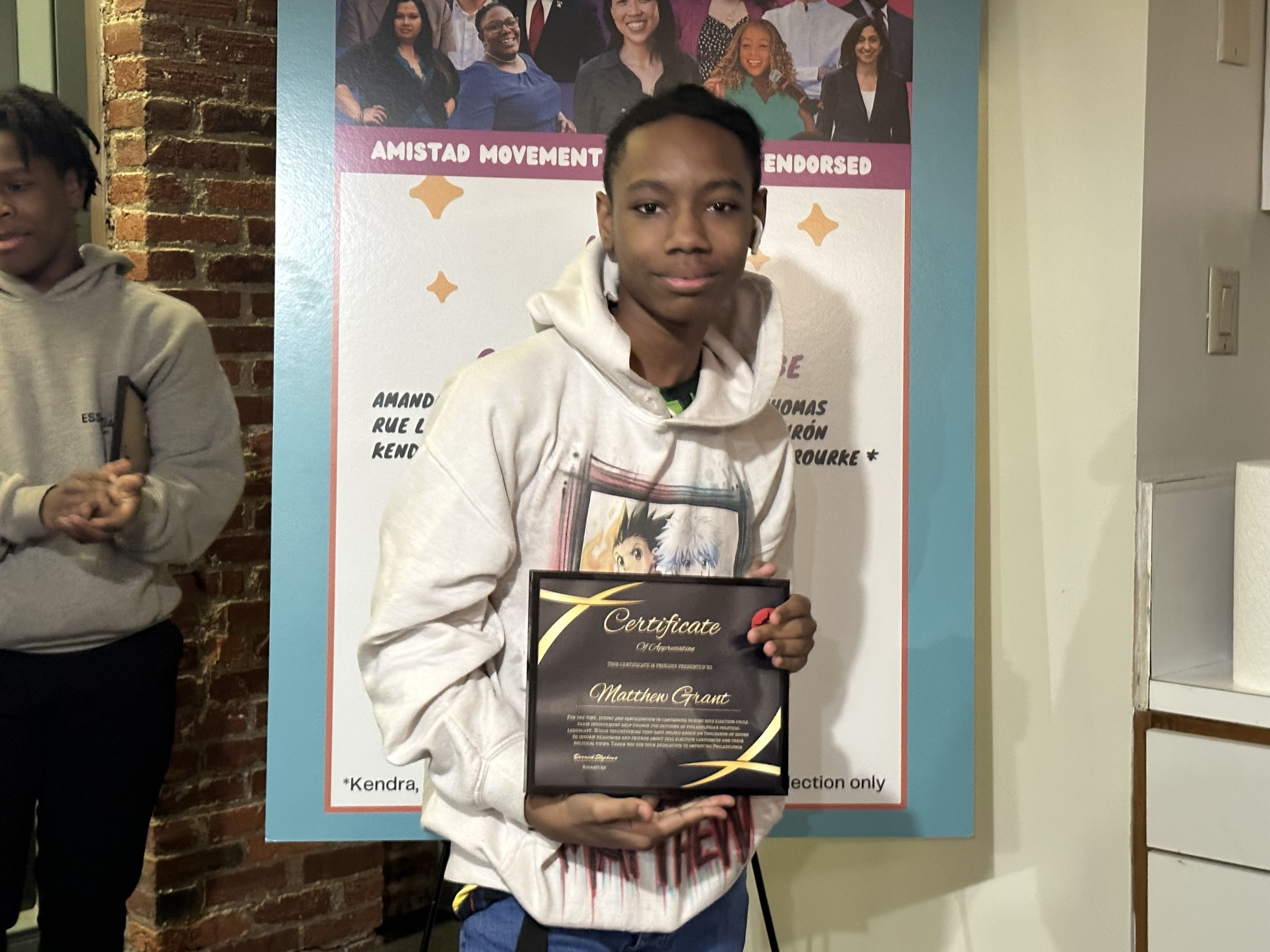 an AMP volunteer holds his award at the volunteer celebration ceremony