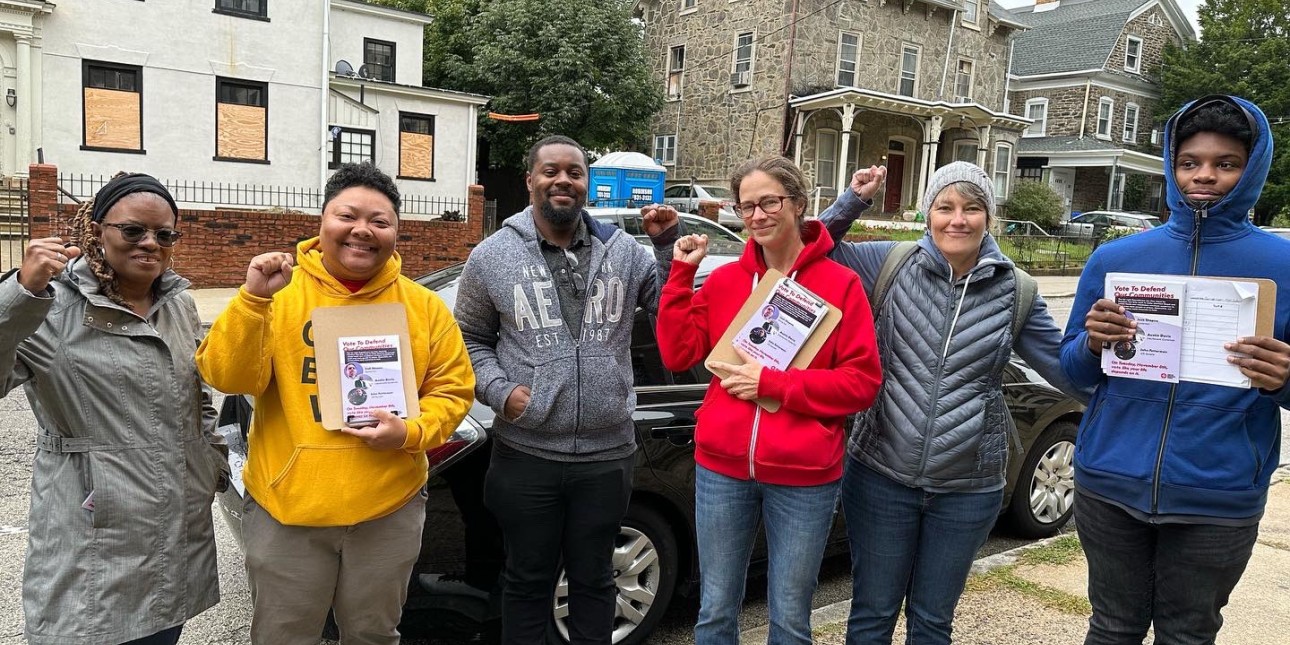 a photo shows a group of people holding literature and getting ready to go door to door to talk to neighbors about voting