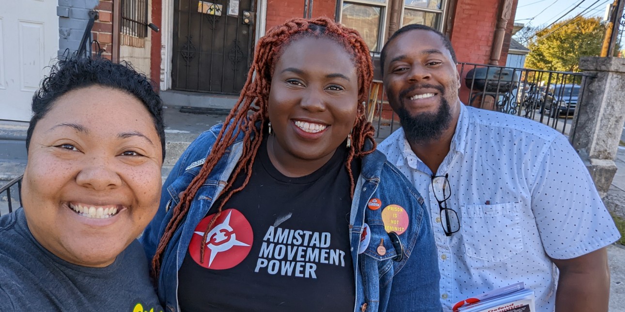 Nikki, Derrick, and Kris smiling on the street doing GOTV on Election Day eve