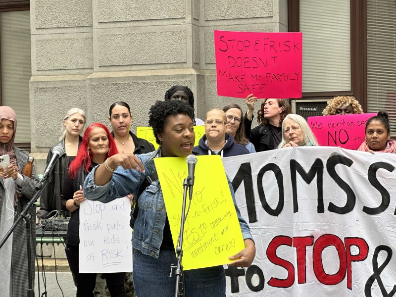 Chantelle Todman speaks in front of a banner that reads Moms Say No to Stop and Frisk