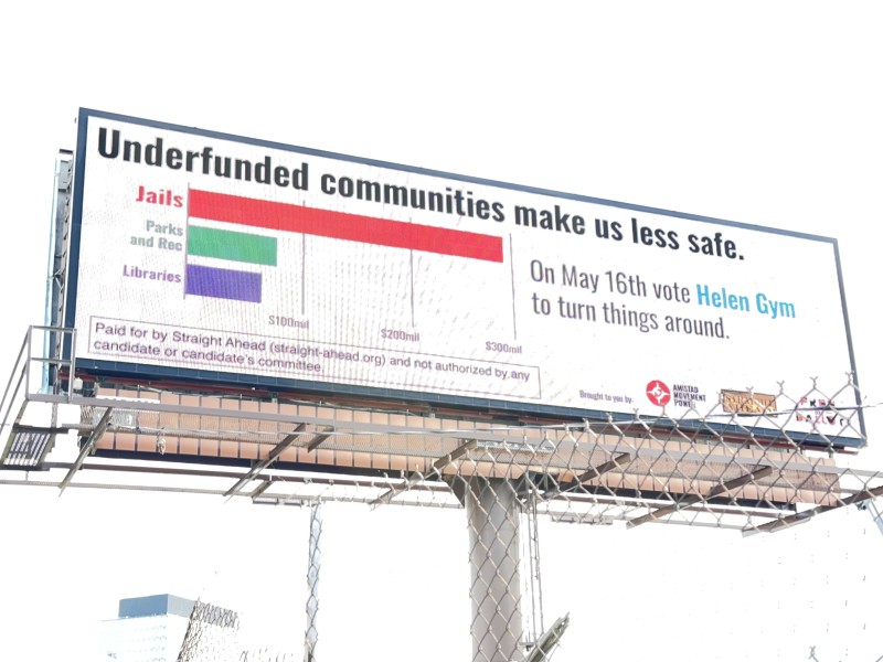 A billboard says 'Underfunded Communities Make Us Less Safe. On May 16 vote Helen Gym to turn things around.'