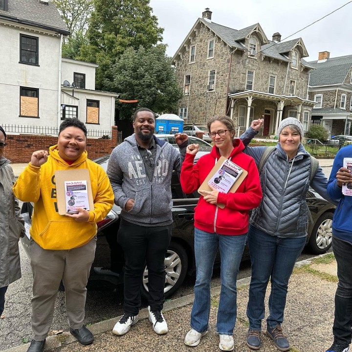 a photo shows a group of people holding literature and getting ready to go door to door to talk to neighbors about voting