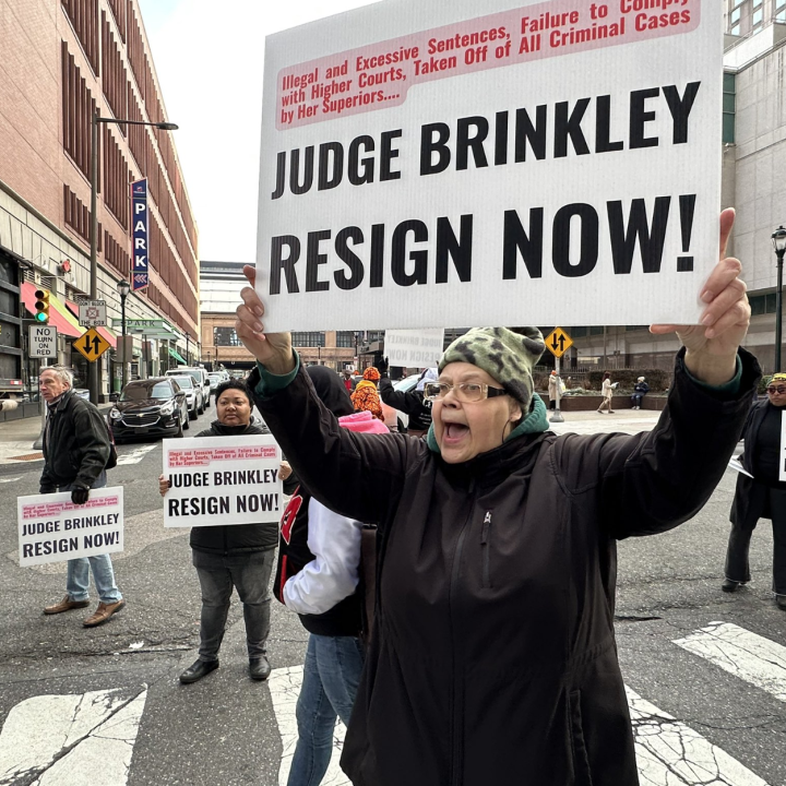 protesters hold signs calling for the resignation of Judge Genece Brinkley